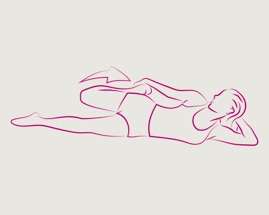 Жена, легнала на една страна, хванала стъпалото си, изпълняваща упражнение за разтягане на четириглавия мускул